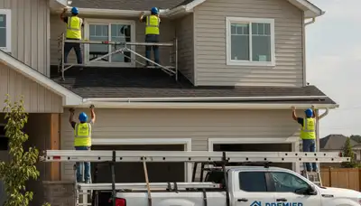 Technician installing seamless gutters on vinyl siding home in Virginia Beach VA